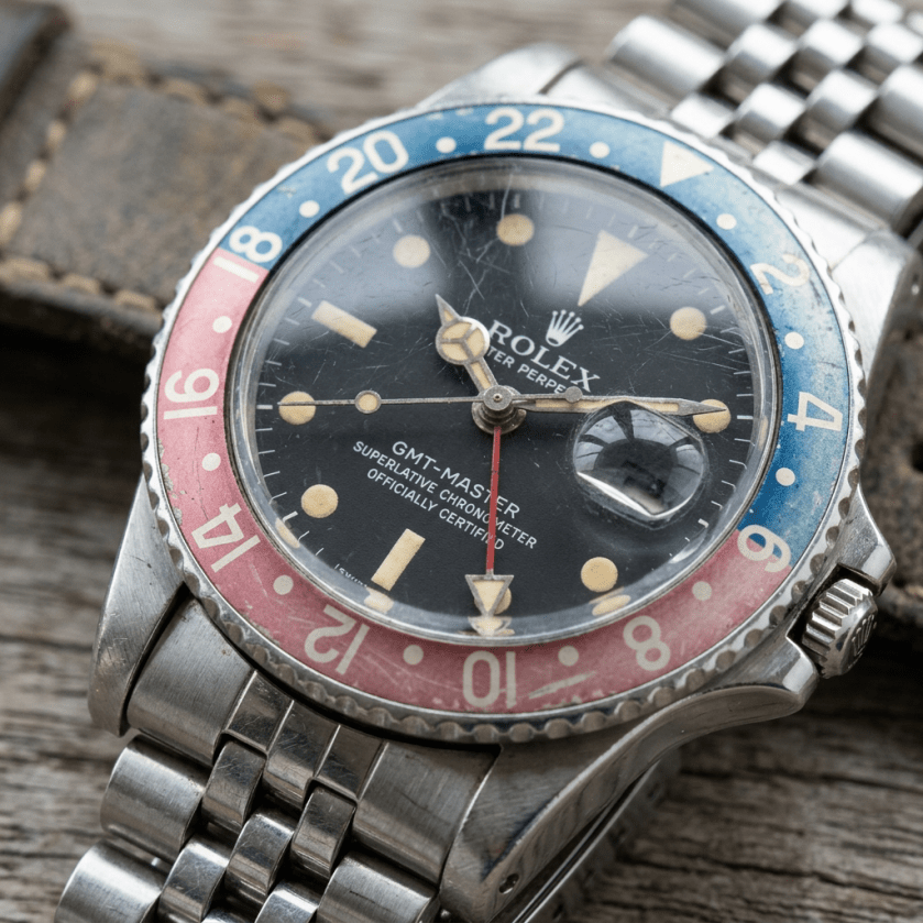 Vintage Rolex GMT-Master watch with faded red and blue bezel and aged dial