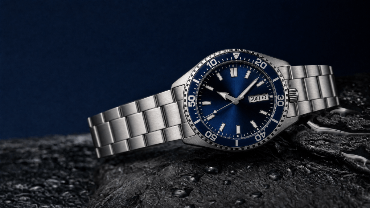 Editorial illustration of a blue-dial Orient Kamasu automatic dive watch on wet slate.